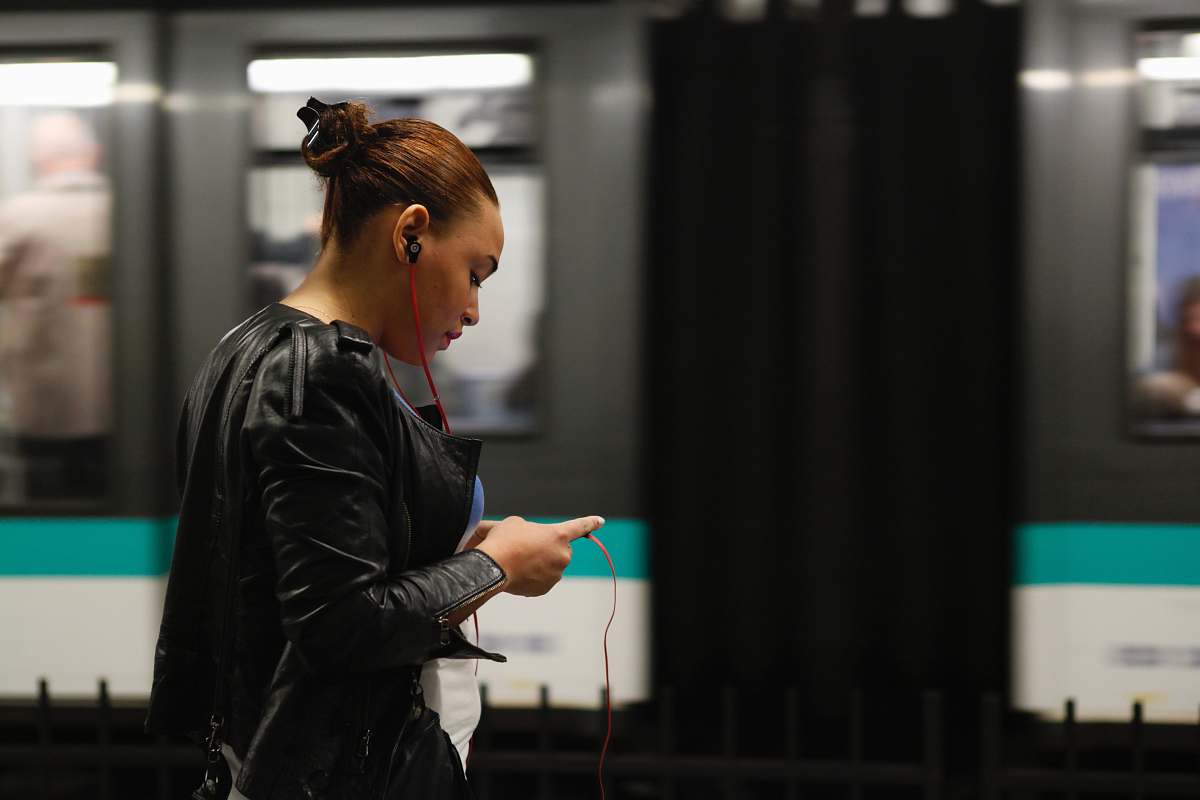 person woman using phone near train apparel