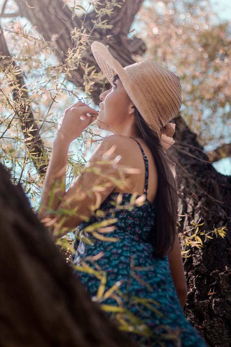 person woman wearing gray sun hat beside tree people