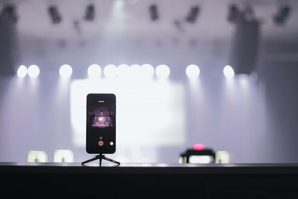 recording selective focus photography of iPhone displaying theater stage
