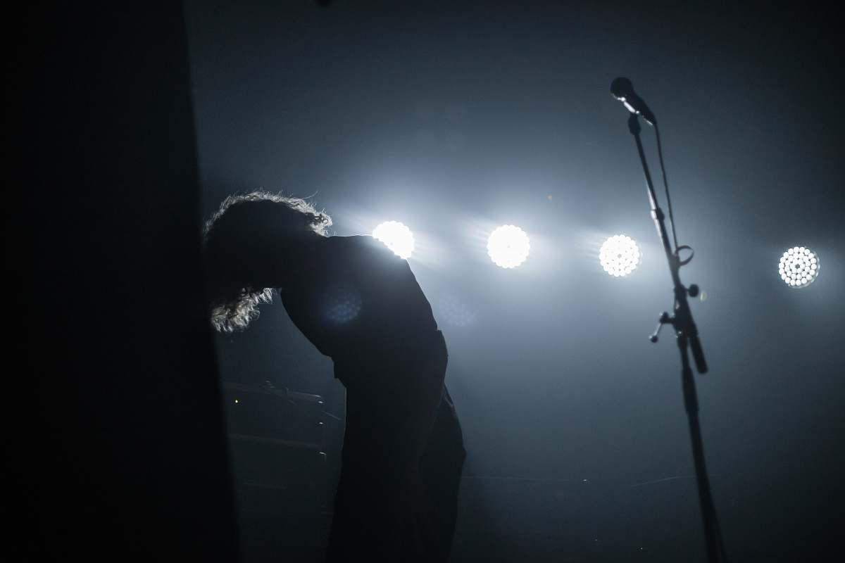 flare person standing beside microphone stand light