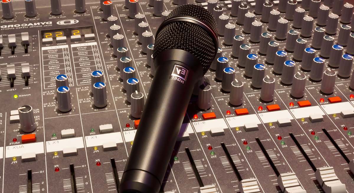 microphone black wireless microphone on grey and multicolored audio mixer mixing console