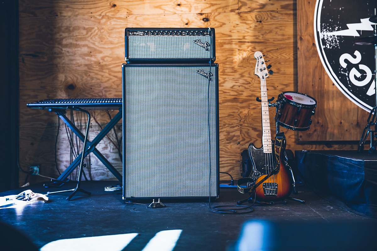 guitar grey and black PA speakers near electric guitar and drum air conditioner