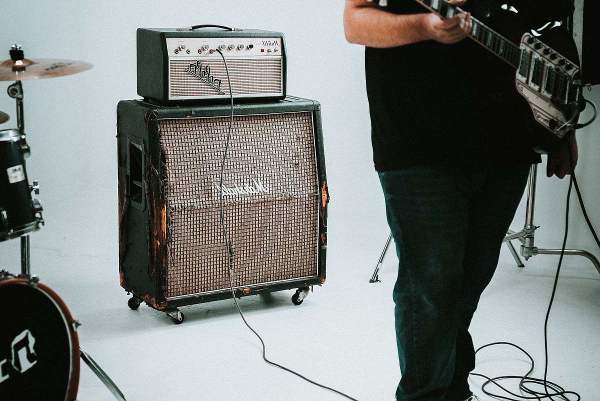 person guitar amplifier near drum instrument human