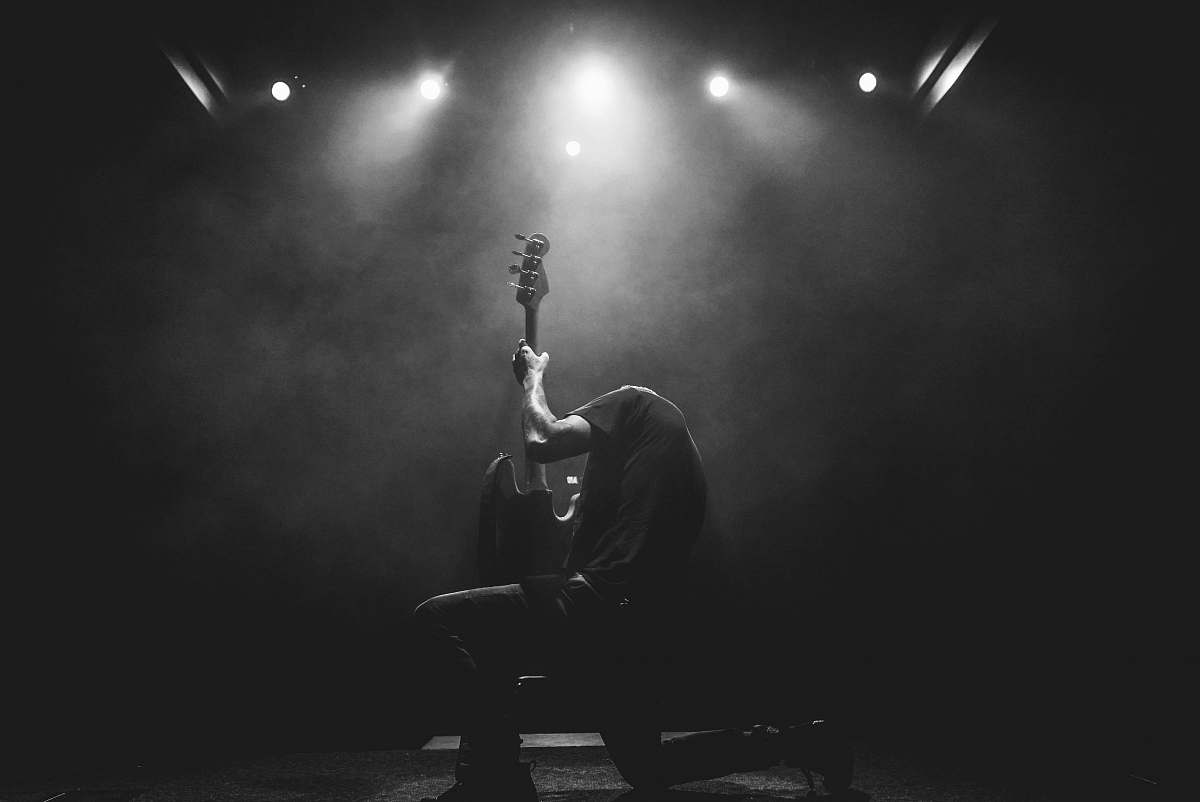 black-and-white lead guitarist doing guitar show on stage grey