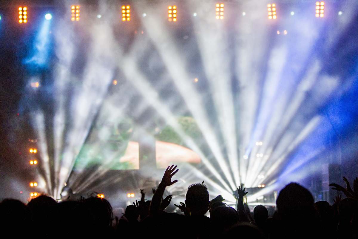 crowd lighted stage full of people concert