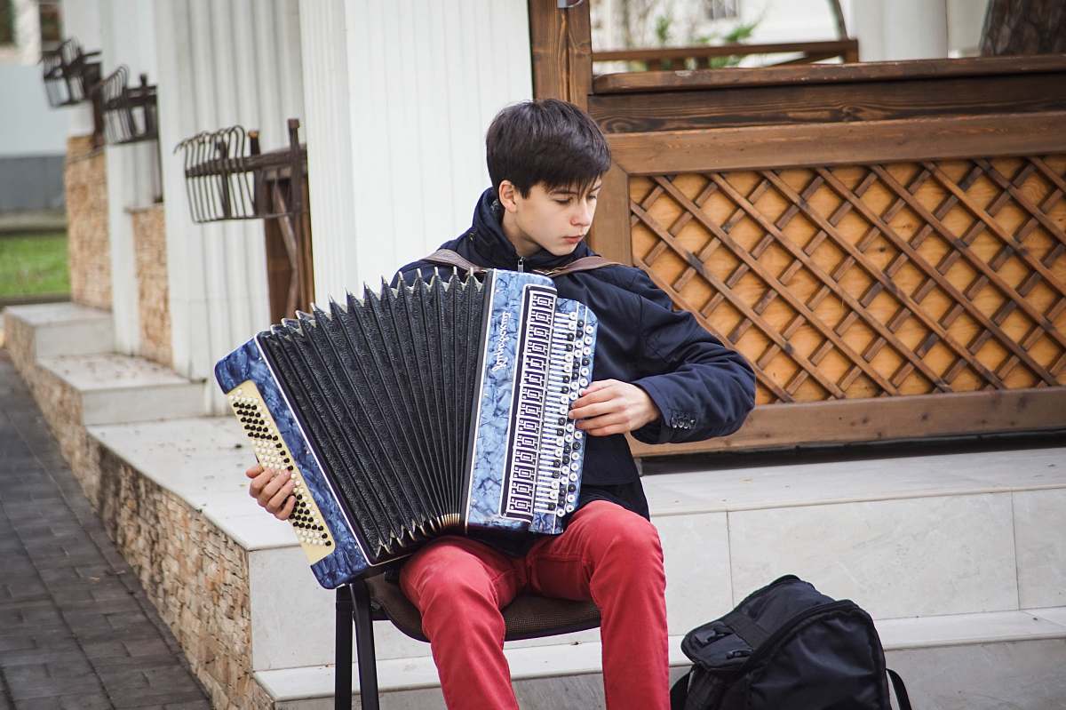 accordion man playing blue accordion during daytime leisure activities