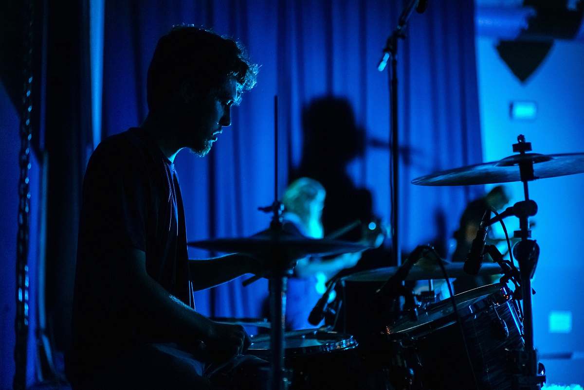 blue man playing drum set drummer