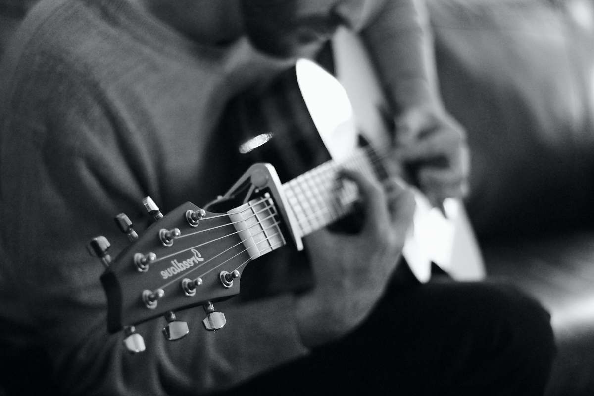 black-and-white man playing guitar grayscale photo musician