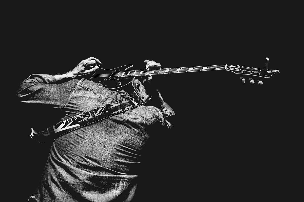 guitar man playing guitar on his back black-and-white