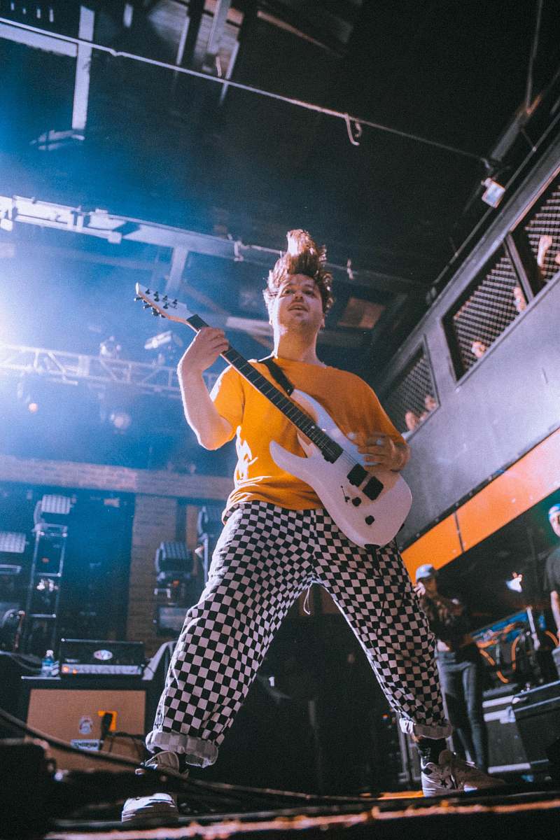 Experience the electrifying atmosphere of live music with this stunning image of a guitarist passionately performing on stage. Captured during a captivating performance by the band 'The 1975' at the Corporation Hall in Sheffield, England on October 20, 2014, this photo encapsulates the raw energy and artistry of a live concert. Perfect for music blogs, event promotion, or any creative project celebrating the spirit of live performances.