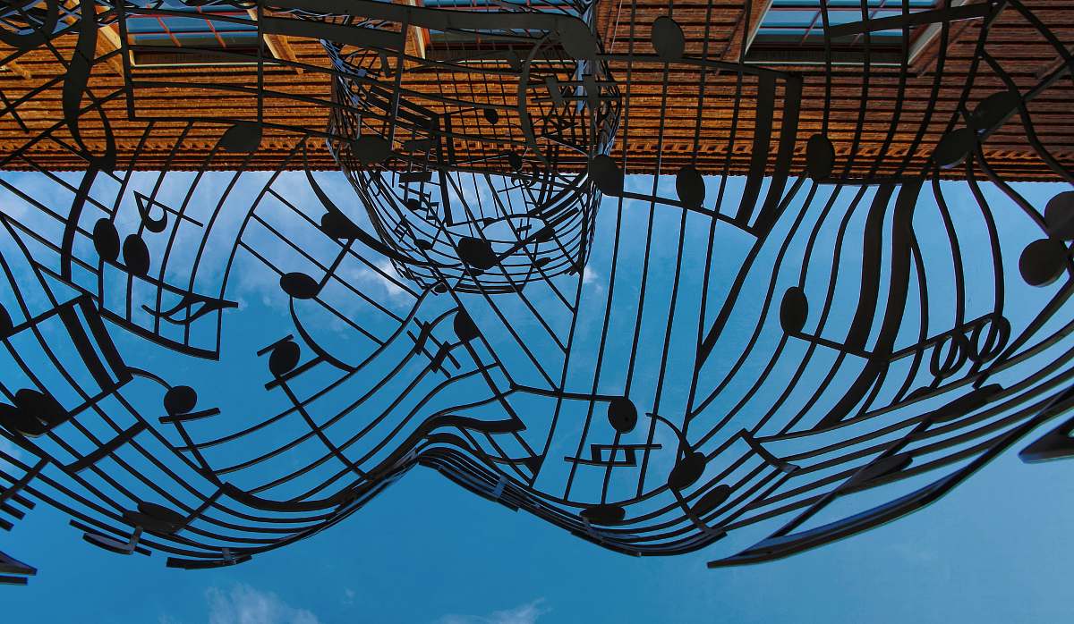 blue musical notes themed metal artwork under blue sky at daytime art