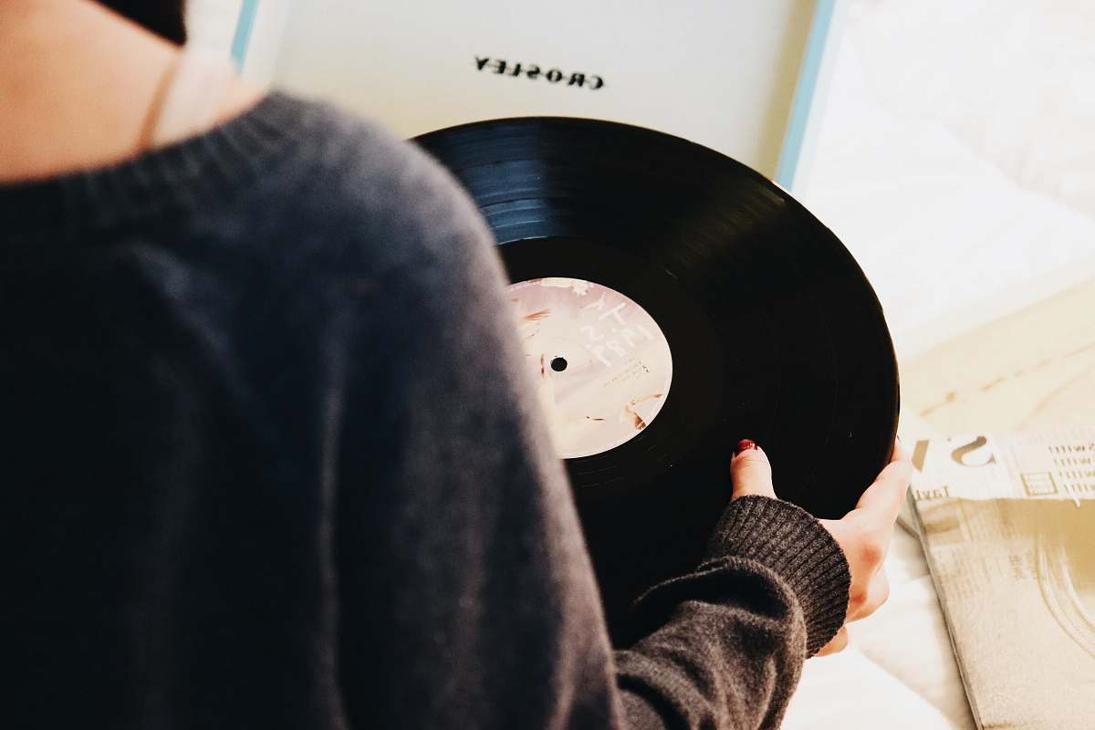 record person holding black vinyl record hand