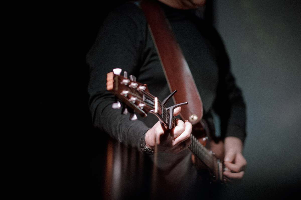 guitar person playing brown guitar instrument