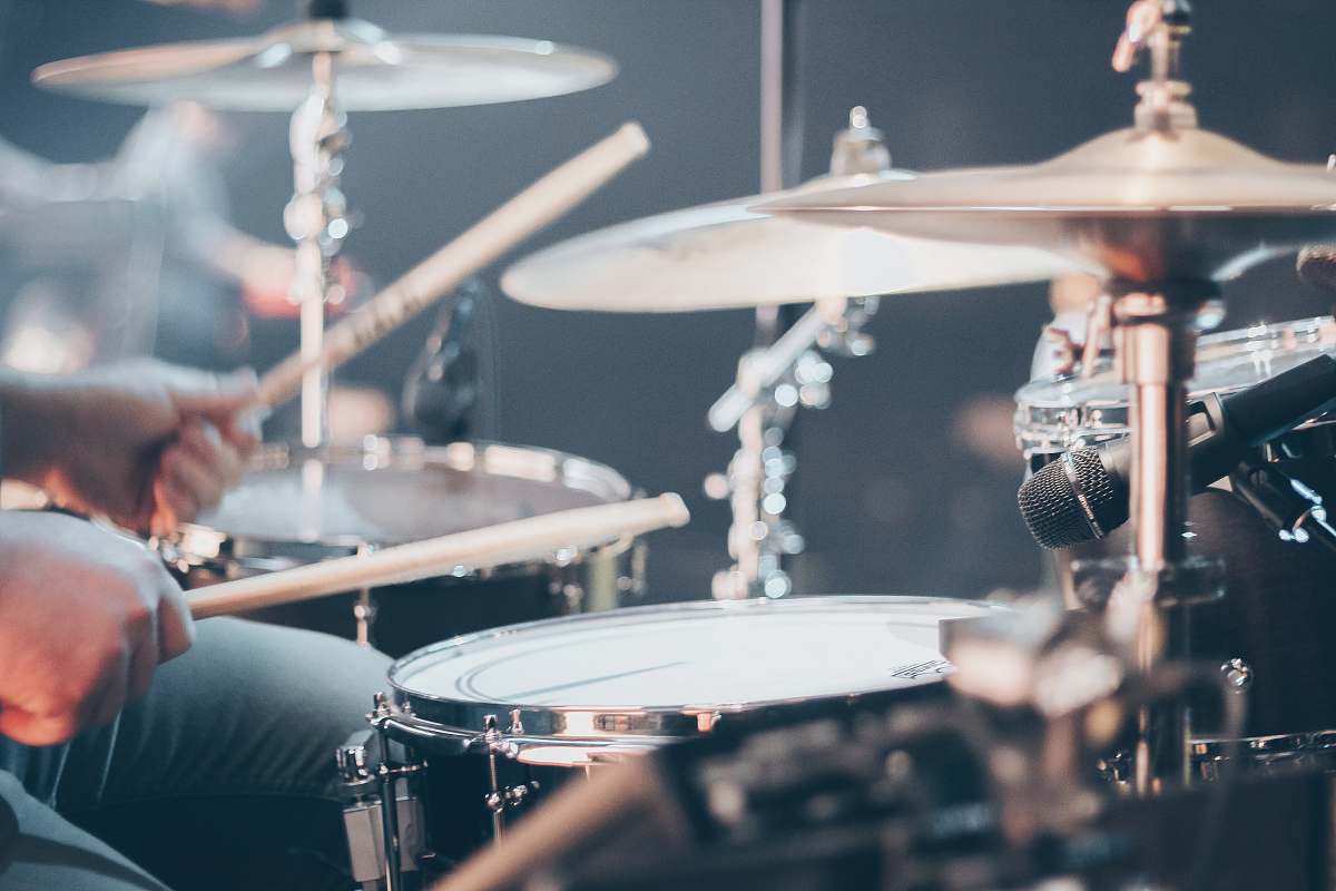 grey person playing drums drum