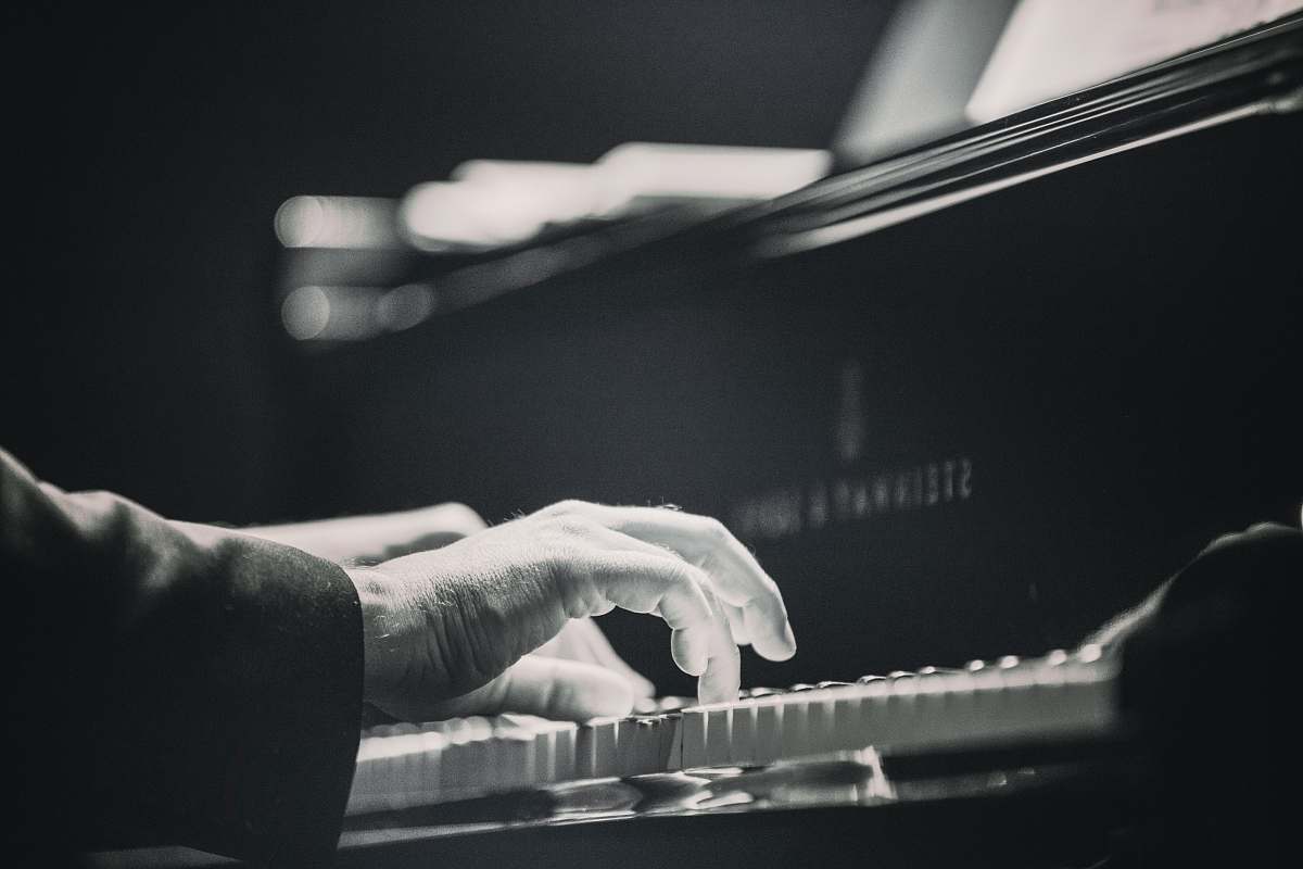 grey person playing piano piano