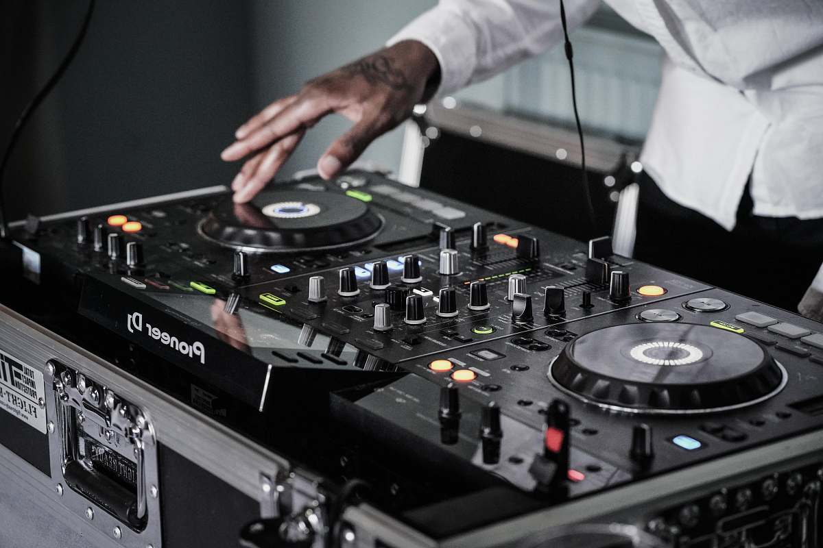 human person touching black terminal mixer dj