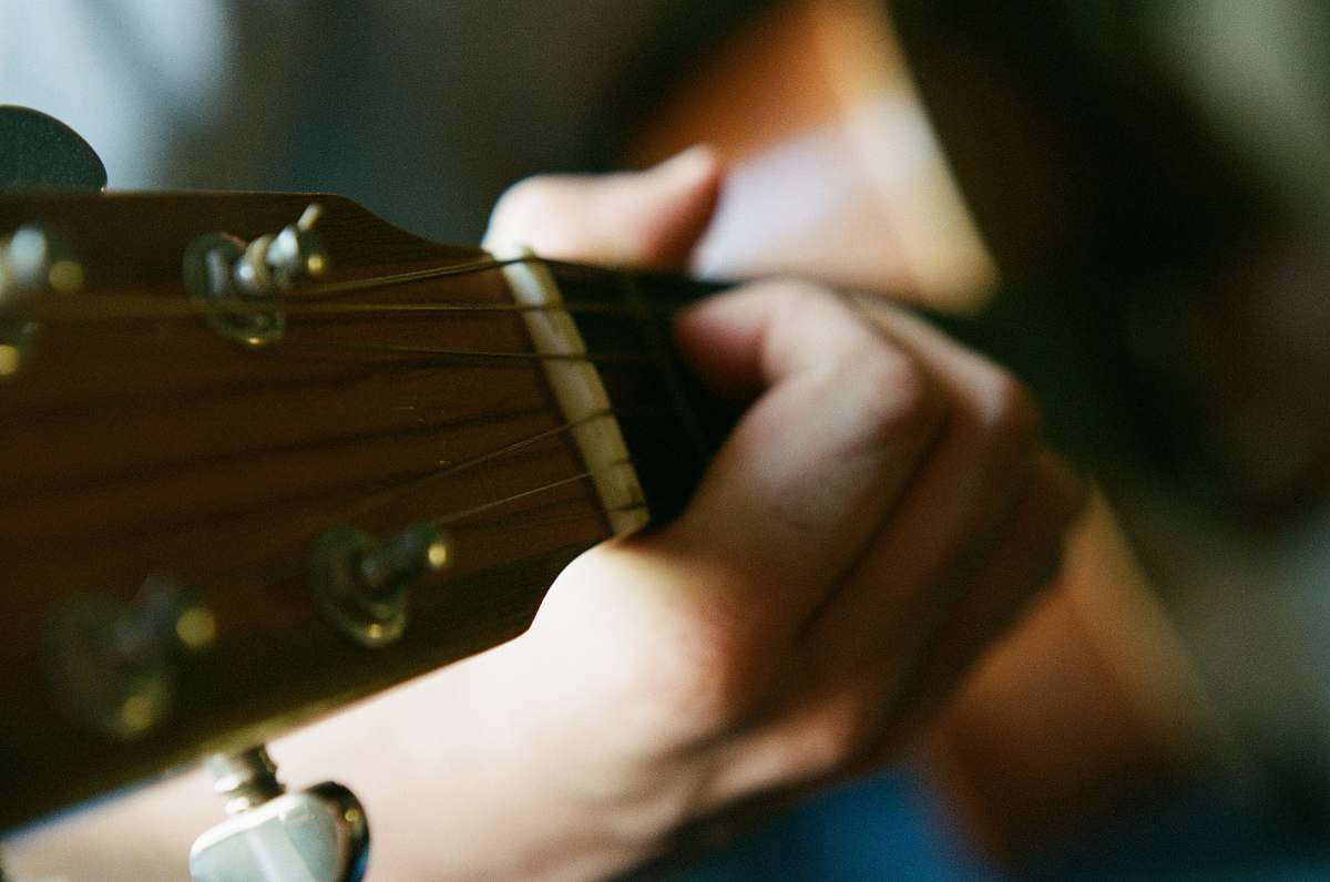 guitar selective focus photography of person playing guitar musician