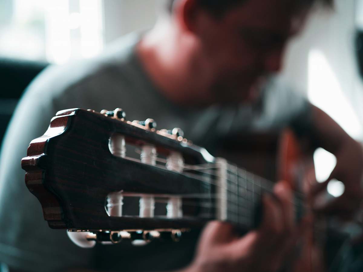 human tilt-shift lens photography of headtock guitar