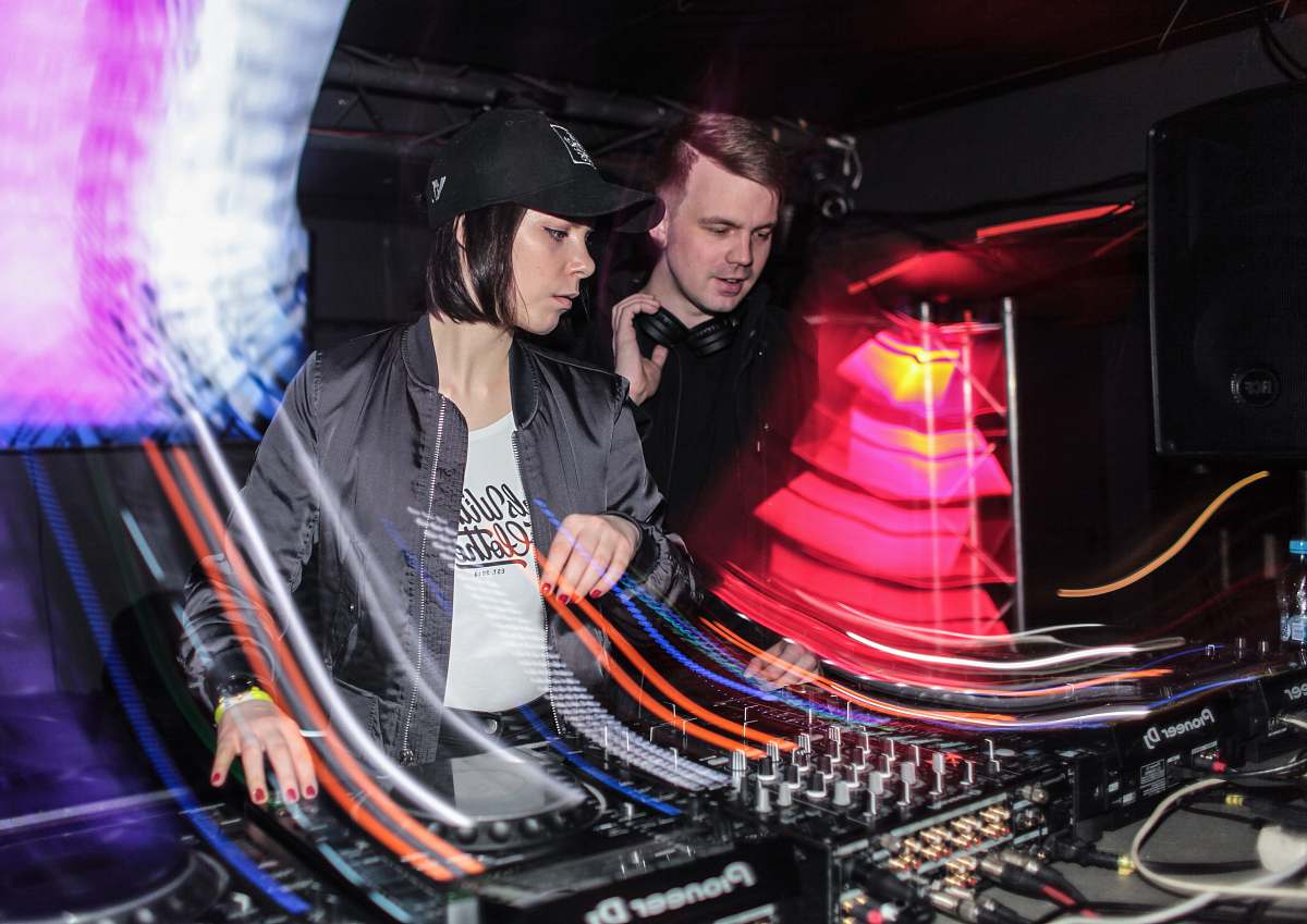 person two DJ's controlling mixing console dj