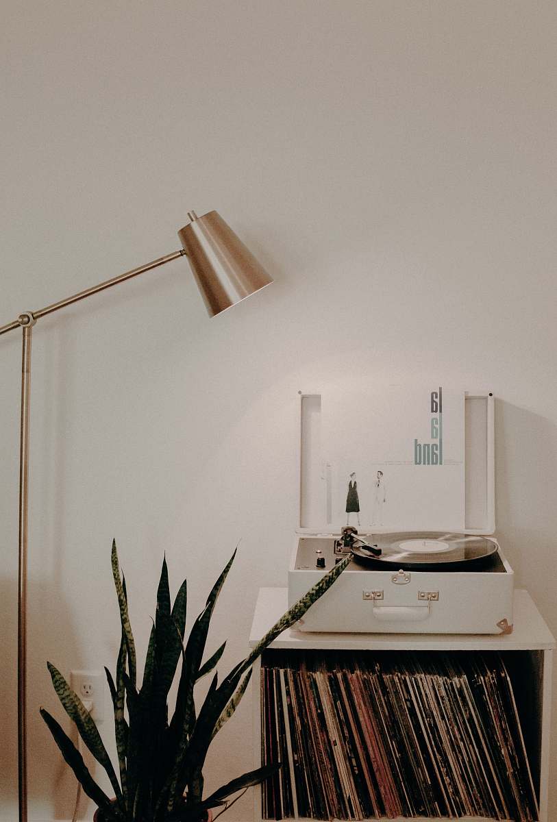 interior white turntable on white wooden organizer with vinyl record sleeves home