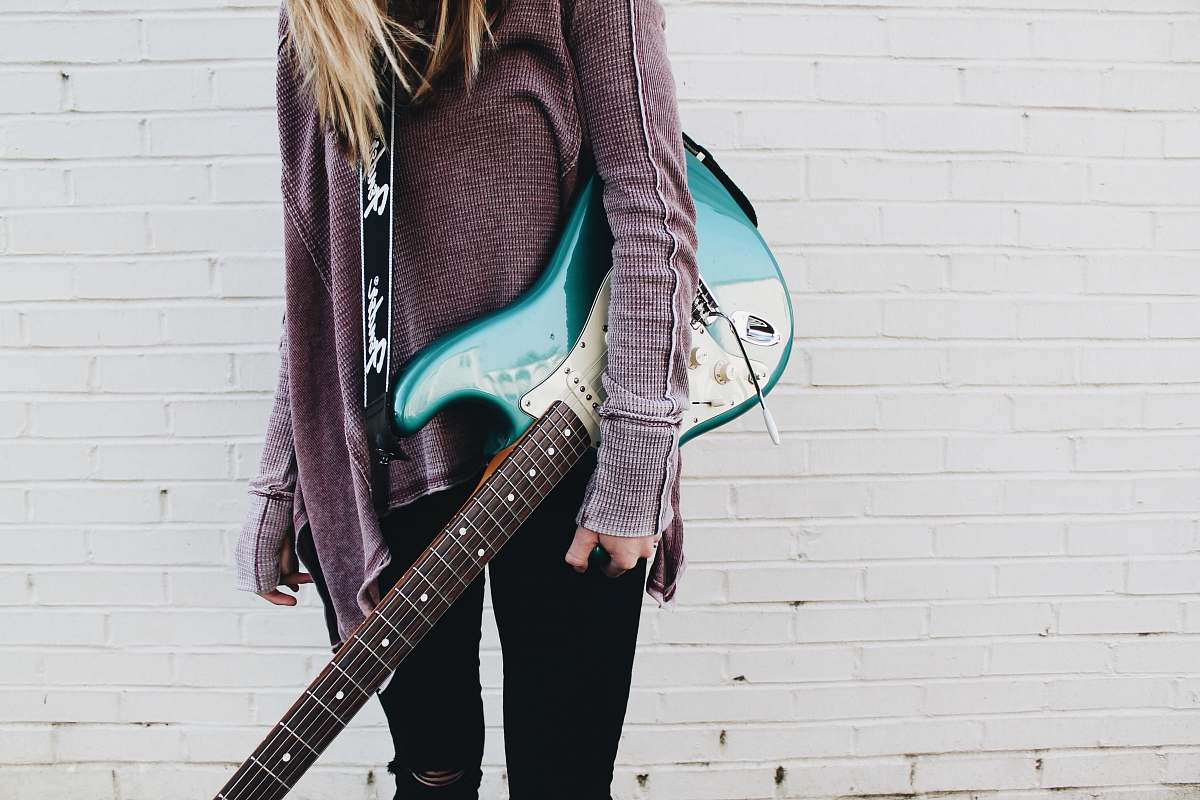 guitar woman carrying green stratocaster guitar musician