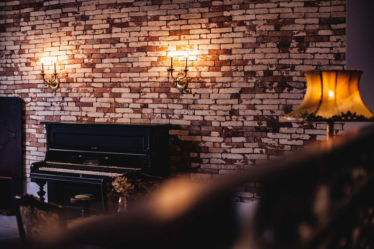 human black upright piano near brown lampshade person
