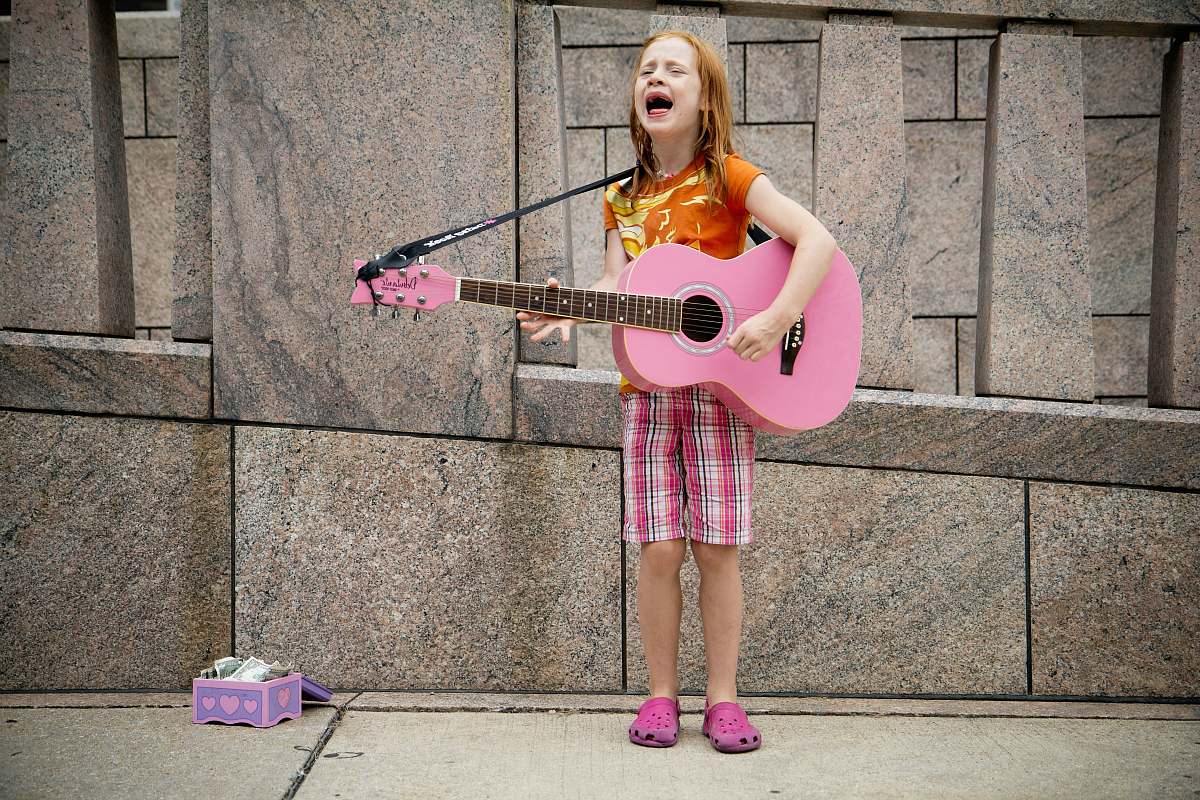 human girl playing guitar near wall person