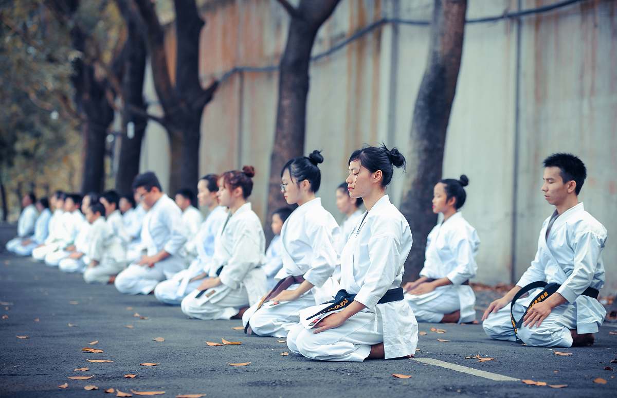 human group of martial artists sitting on the grounds person