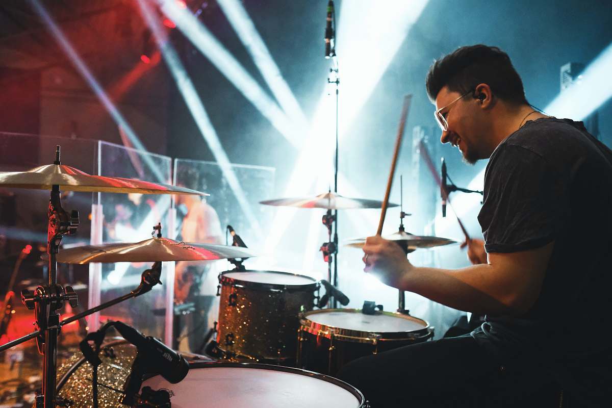 human man playing drums on stage person