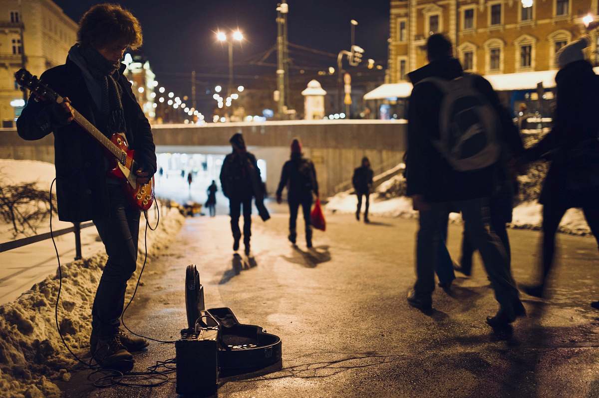 person man playing guitar on street during nighttime human