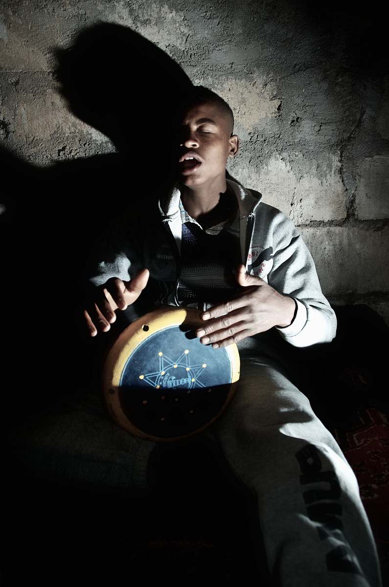 human man playing percussion instrument near wall person