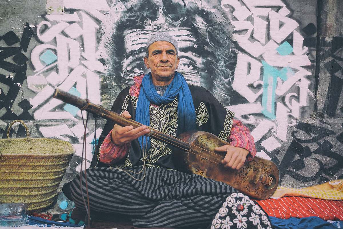 person man playing string instrument beside brown basket human