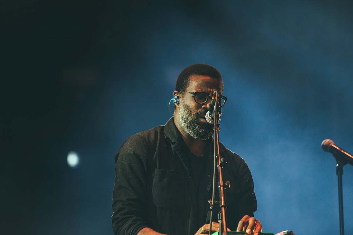 human man standing facing microphone person