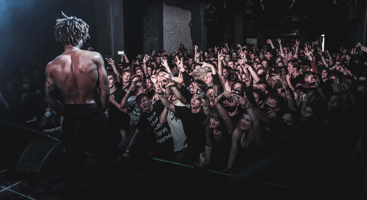 human man standing on stage crowd