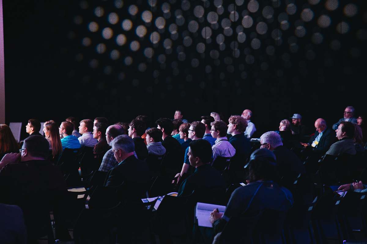 human crowd of people sitting on chairs inside room people