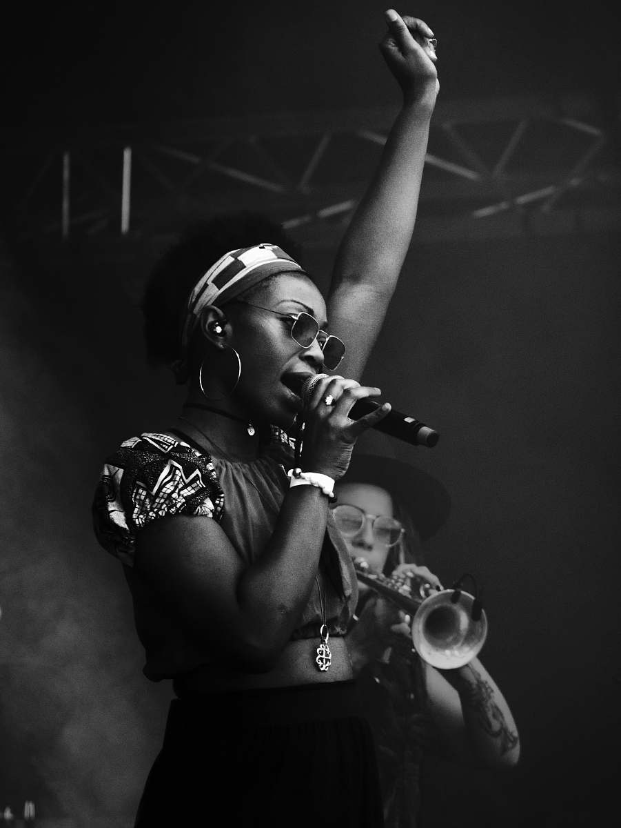 human grayscale photography of woman holding microphone black-and-white