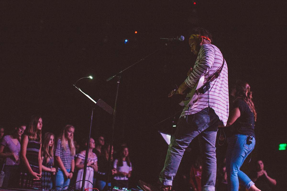 human man and woman performing on stage in front of crowd people