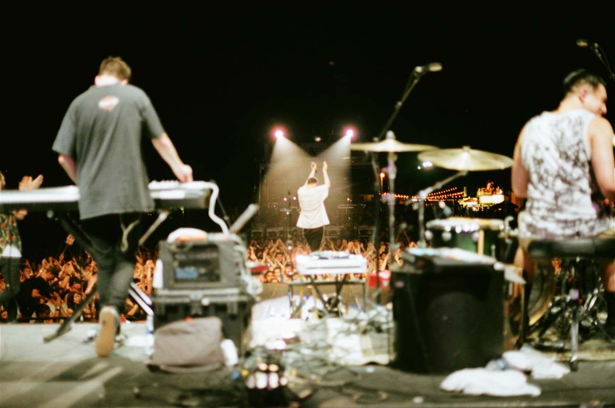 human man in black t-shirt standing while playing black electronic keyboard during daytime people