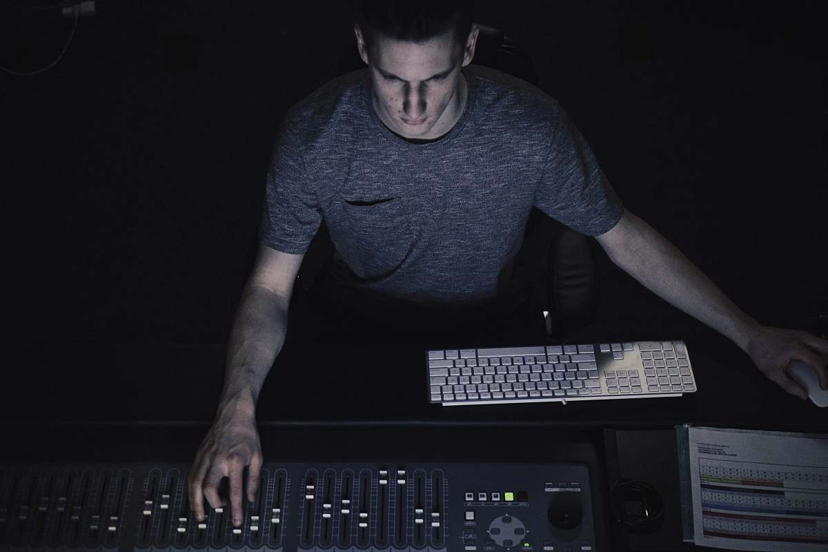 human man in gray shirt using sound equalizer dj