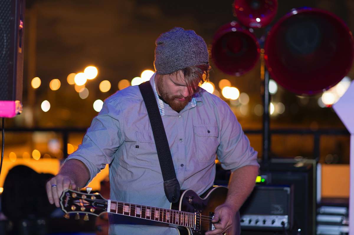 human man playing acoustic guitar people