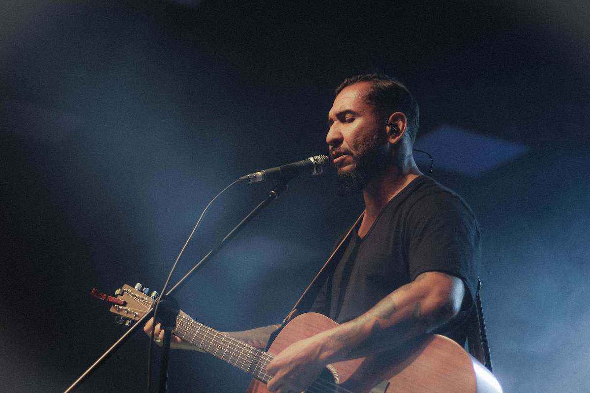 human man playing guitar while singing people