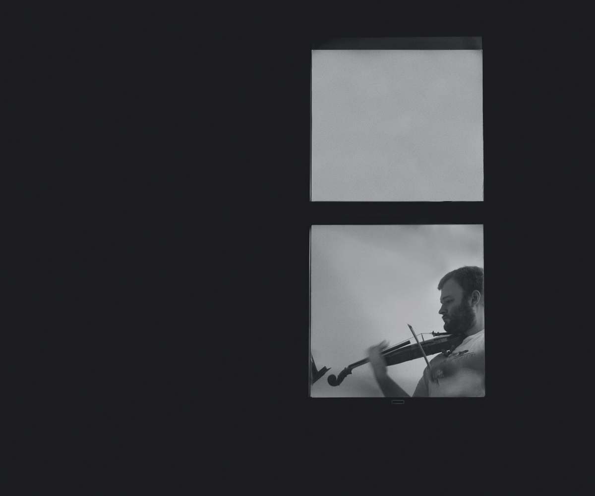 black-and-white man playing violin near glass window speech