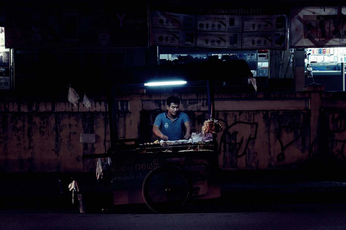 human man standing beside food stand people