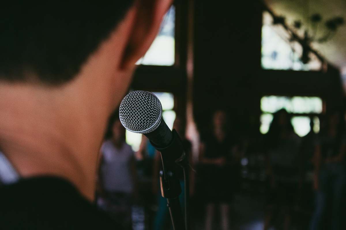 human man standing in front of microphone people