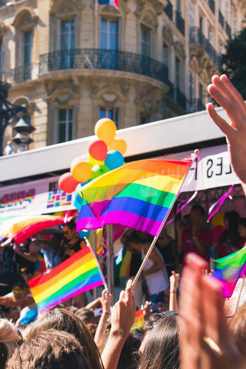 human people holding yellow, green, blue, and purple flag people