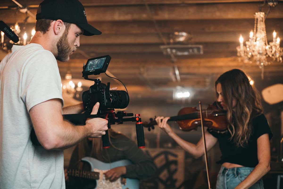 human person holding black video camera apparel