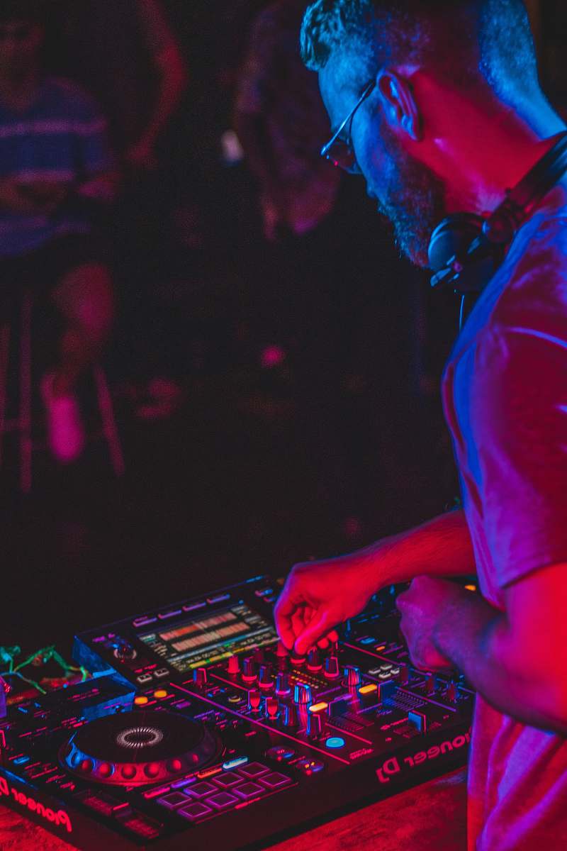 human person playing audio mixer in concert dj