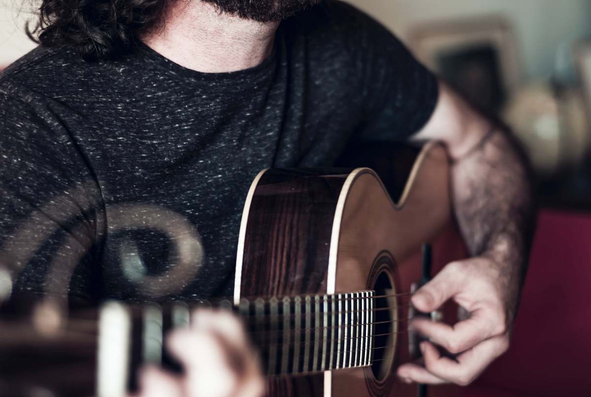 human person playing brown acoustic guitar people