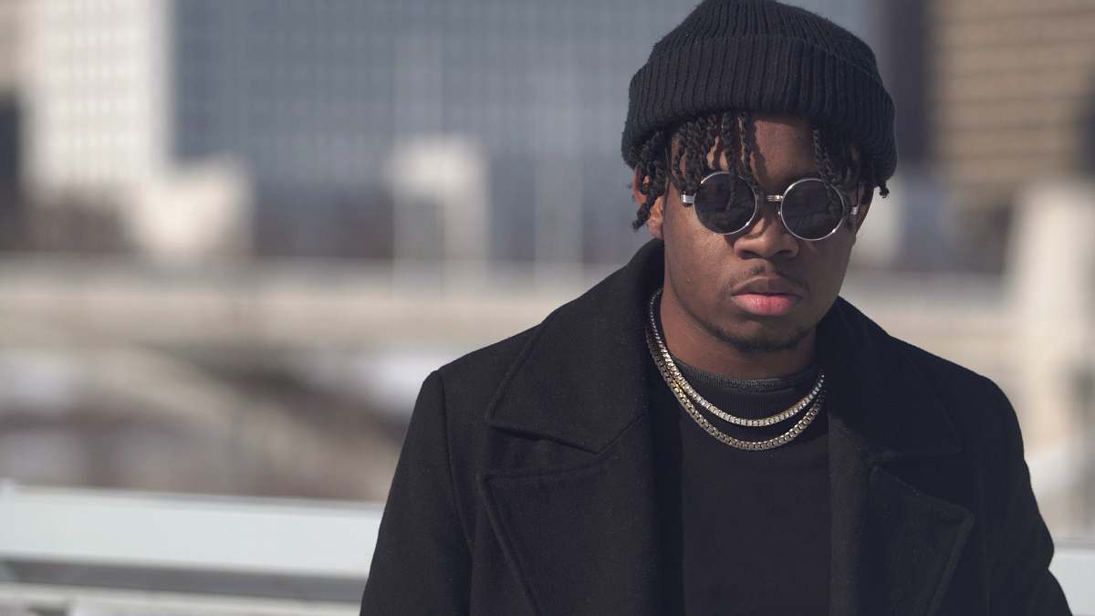 apparel selective focus photography of man wearing black knit hat and sunglasses clothing