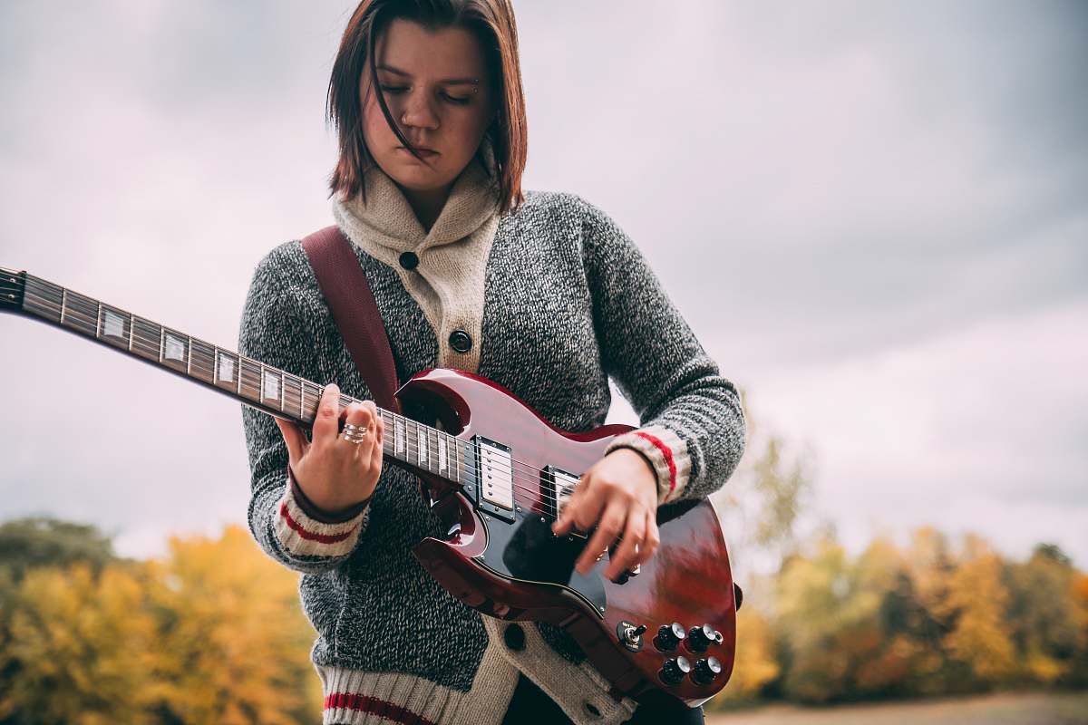 human woman playing guitar during daytime people